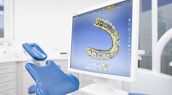 Ansicht eines Arbeitsplatzes auf dessen Monitor man ein 3D Modell eines Kiefers sieht